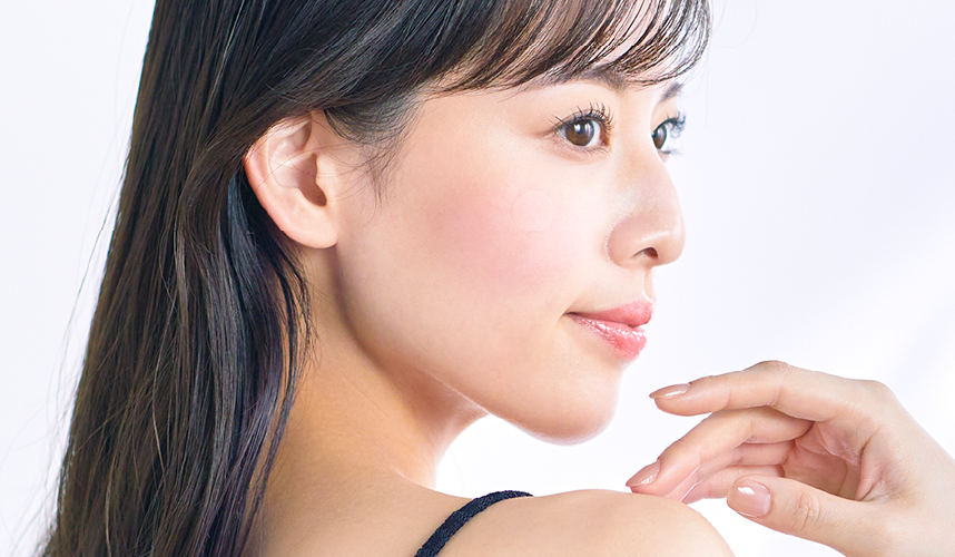 鏡で肌を確認する女性の写真